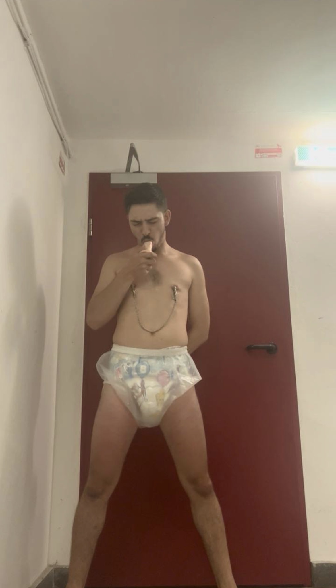 Diapered slave sucking a dildo in public